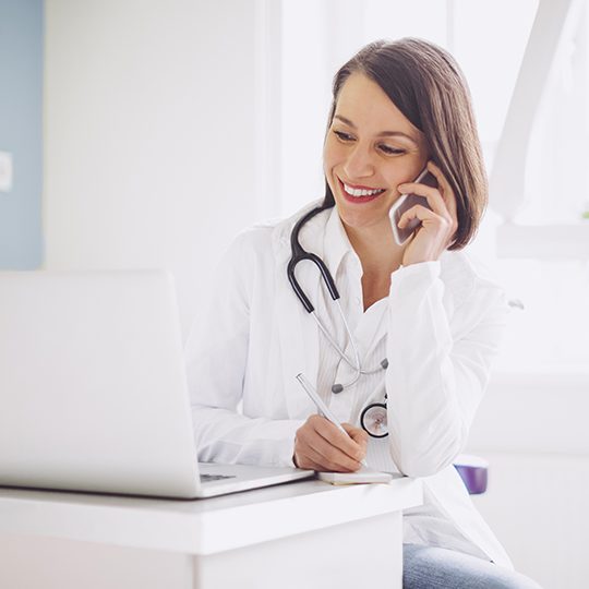 medica con telefono y computadora